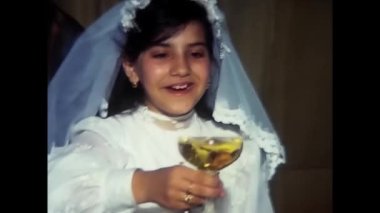 palermo, italy may 1980: People eat and converse to celebrate a young girl's First Communion at a lunch at a restaurant in the 1980s.