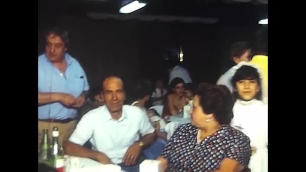1980年5月イタリア パレルモ 1980年代のあるレストランでの昼食会で 若い女の子の最初のコミュニケーションを祝うために人々は食べたり話したりします — ストック動画