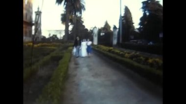 palermo, italy may 1980: father and daughter walking down a street in the 80s