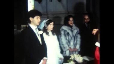 Palermo, Italy December 1980: Wedding celebration of two spouses in church with the priest and all relatives in the 80s.