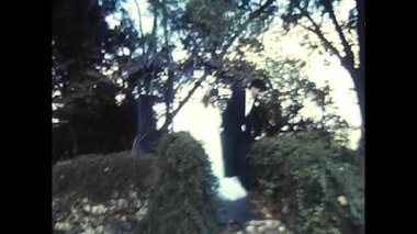 palermo,italy december 1980: happy bride and groom kiss in a park in the 80s