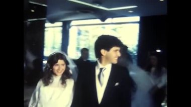 palermo,italy december 1980: bride and groom arrive at the restaurant and sit at the table in the 80s