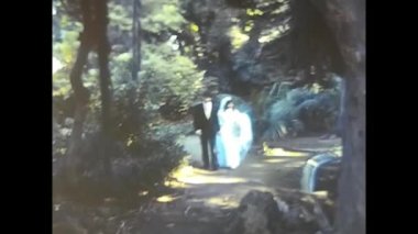 palermo,italy december 1980: happy bride and groom kiss in a park in the 80s