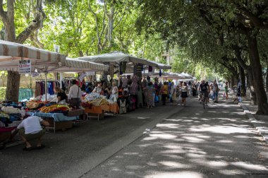 Terni, İtalya 19 Temmuz 2023: Mobil tezgahları ve alışveriş yapan insanlarla parkta haftalık fuar