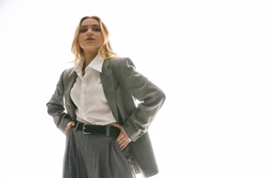 Şık genç bir kadın, kendine has tarzını sergileyerek, parlak bir arka plana karşı poz veriyor..