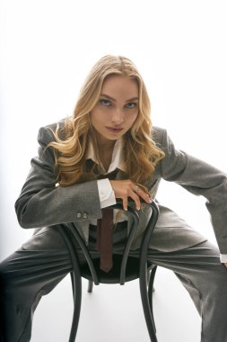 Şık giyinmiş genç bir kadın zarif bir şekilde poz veriyor, çağdaş tarz ve özgüveni vurguluyor..