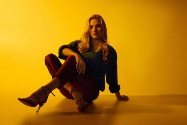 Genç kadın kendine güven ve cazibe saçar. Güzel giysiler içinde. Tarz sahibi izleyicileri büyüler..