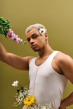 Genç bir Afrikalı Amerikalı, atölyede çiçeklerle süslenmiş, kendine güvenen bir bluzla poz veriyor..