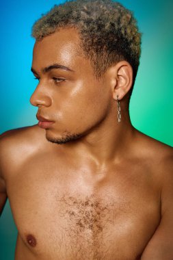 Genç, üstsüz, Afro-Amerikan bir adam güzelliğini ve modasını canlı stüdyo ışıklarıyla sergiliyor..
