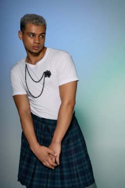 Kendine güvenen genç bir Afrikalı Amerikalı, canlı bir stüdyo ortamında şık giyinmiş poz veriyor..