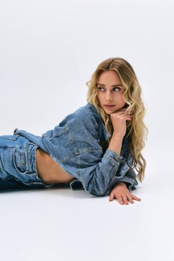 Sarışın, dalgalı saçlı, kot pantolon giymiş, şık stili ve zarafetini sergiliyor..