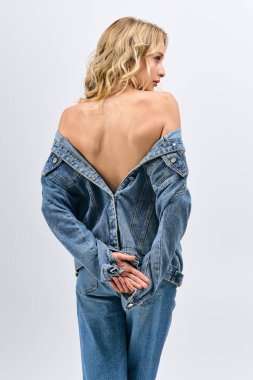 Sarışın kadın kendine güvenerek modern moda sergiliyor. Benzersiz stilini ve zarafetini vurguluyor..