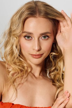 Göz kamaştırıcı sarı bukleli genç bir kadın moda anlayışı ve özgüvenini sergiliyor..