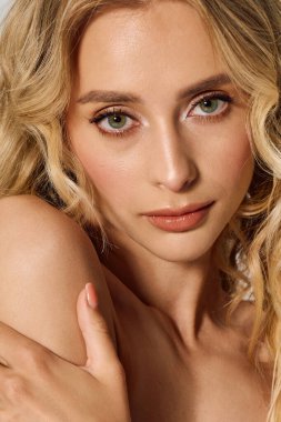 Sakin bir ortamda, dalgalı sarı saçlı genç bir kadın doğal güzelliğini ve tarzını sergiliyor..