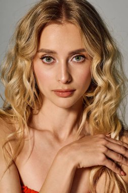 Genç, güzel bir kadın sanatsal poz verirken zarafetini uzun sarı dalgalarla sergiliyor..