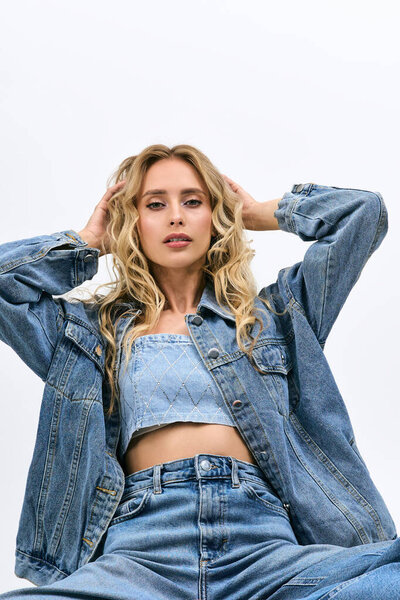 In a chic denim ensemble, a young blonde woman showcases her fashion sense and confidence.