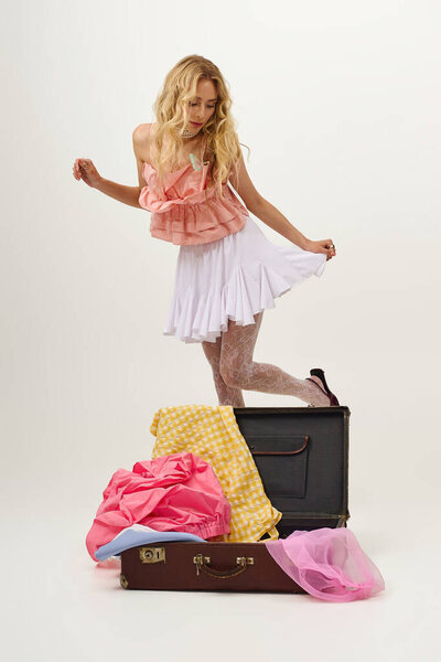 Блондинка играет с различными красочными нарядами, демонстрируя свое чувство стиля и творчества.