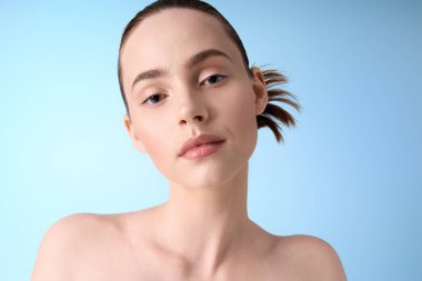 Tarz sahibi genç bir kadın şık bir saç stiliyle kendine güvenerek poz verir, çağdaş zarafet yayar..