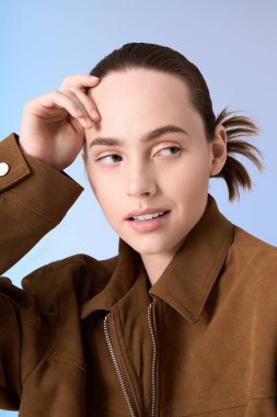 Çekici genç bir kadın zarif bir şekilde poz veriyor. Yumuşak bir zemin üzerinde, ileri moda titreşimleri yayıyor..