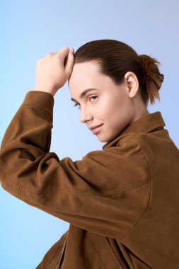 Şık ve çağdaş, modaya uygun genç bir kadın tarzını sergileyerek kendine güvenen bir poz veriyor..