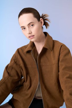 Kendine güvenen genç bir kadın zarif, renkli bir stüdyo ortamında çağdaş moda sergiliyor..