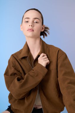 Tarz sahibi bir kadın şık kahverengi ceketini dengeli bakışlarıyla ve büyüleyici bakışlarıyla mankenlik yapıyor..