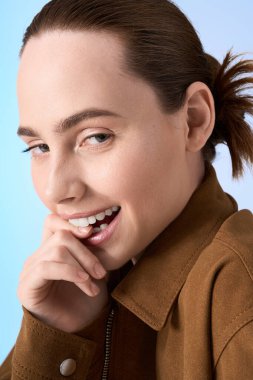 Genç ve güzel bir kadın gülümseyerek moda anlayışını sergiliyor, neşeli bir atmosfer yaratıyor..