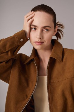 Genç ve güzel bir kadın, kendine güvenen bir şekilde poz verirken eşsiz moda anlayışını ifade eder..