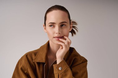 Genç ve güzel bir kadın, modaya uygun kıyafetler giyip modern moda atmosferini yansıtıyor..