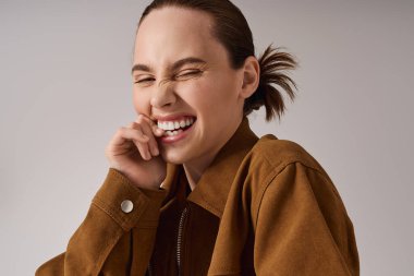 Genç, güzel, modaya uygun bir kadın neşeli bir şekilde poz verirken ve tarzını sergilerken neşe saçıyor..