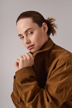 Genç ve güzel bir kadın, modaya uygun bir şekilde ceketini düzeltirken....