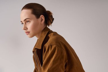 Şık bir stüdyo ortamında modaya uygun giyinmiş zarif genç bir kadın..