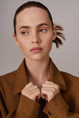 Şık bir genç kadın zarif bir kıyafet ve özgüvenli bir ifadeyle moda anlayışını sergiliyor..