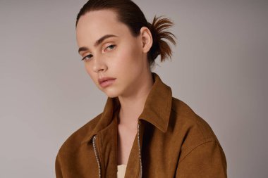 Modaya uygun genç bir kadın, sakin bir ifadeyle çağdaş tarz ve kendine güven sergiliyor..