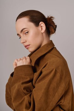 Çekici genç kadın, moda kıyafetlerini içeriden modellerken kendine güven ve tarz yayıyor..