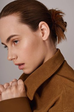 Modayı takip eden genç bir kadın sofistike bir moda sergiliyor, özgüven ve zarafet saçıyor..