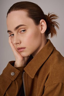 Tarz sahibi genç bir kadın moda anlayışını göstererek düşünceli bir şekilde poz verir..