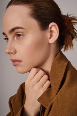 Şık bir genç kadın, çenesini şık bir ortamda özenle dinlendirir..