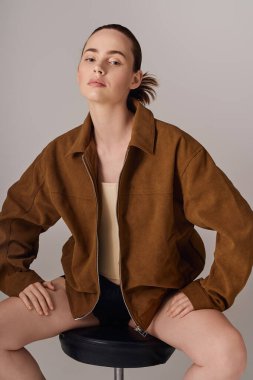 Kendine güvenen genç bir kadın moda anlayışını sakin bir stüdyo ortamında moda kıyafetleriyle sergiliyor..