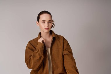 Genç ve güzel bir kadın rahat bir duruş ve kendine güvenen bir ifadeyle moda tarzını sergiliyor..