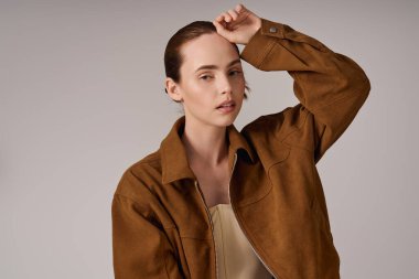 Modaya uygun genç bir kadın şık bir ceket giyip çağdaş tarzın altını çiziyor..