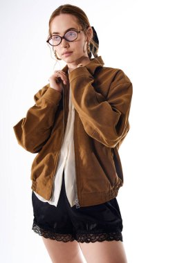 Şık bir ceket ve şortla şık bir kıyafet giymiş genç bir kadın kendine güveniyor..