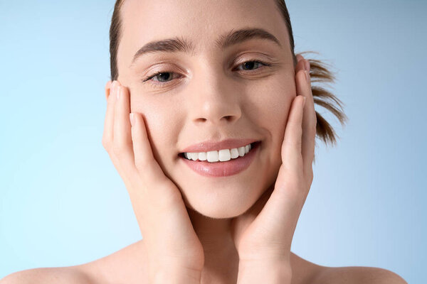 Молодая женщина со стилем нокаута выражает блаженство, мягко убаюкивая лицо, вызывая счастье.