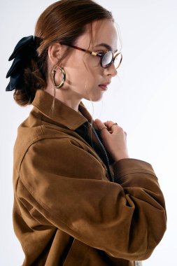 Çekici kadın zarif poz veriyor, modern moda eğilimlerini eşsiz aksesuarlarla somutlaştırıyor..