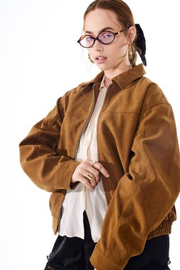 Genç güzellik modern bir stüdyo ortamında poz verirken kendine güvenerek modaya uygun kıyafetler giyer.