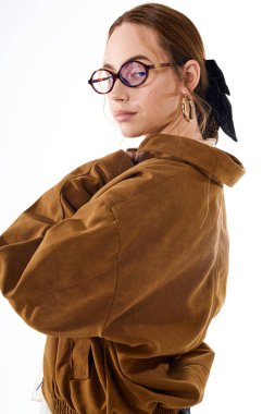 Genç bir kadın eşsiz tarzını sergiliyor. Basit bir arkaplanda zarif aksesuarlar sergiliyor..