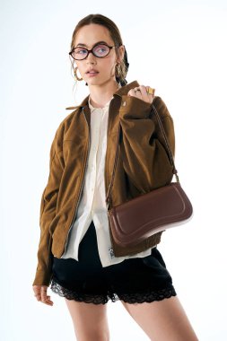 Tarz sahibi genç bir kadın şık görünümünü, modaya uygun bir kıyafete karşı cesur bir güvenle sergiliyor..