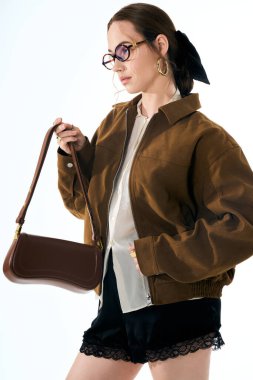 Şık kahverengi ceketli ve zarif şortlu şık bir genç bayan kendine güvenir..