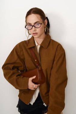 Gözlüklü şık bir kadın, modaya uygun bir şekilde modern modayı sergiliyor..