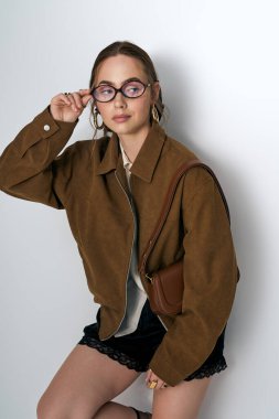 Çekici genç kadın, kendine has moda anlayışını şık katmanları ve aksesuarlarıyla sergiliyor..